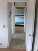 Es gibt helle Fliesen und Fußbodenheizung in allen Räumen des Ferienhauses ausser die zwei Schlafzimmer wo es Holzboden gibt. Das Bild zeigt den Flur zwischen den beiden Schlafzimmern. Auf der linke Seite befindet sich das Badezimmer !